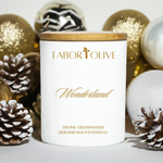 Load image into Gallery viewer, White candle jar with bamboo lid surrounded by gold and white Christmas decorations with gold text that says, &quot;Wonderland. Divine cedarwood geranium and patchouli&quot;
