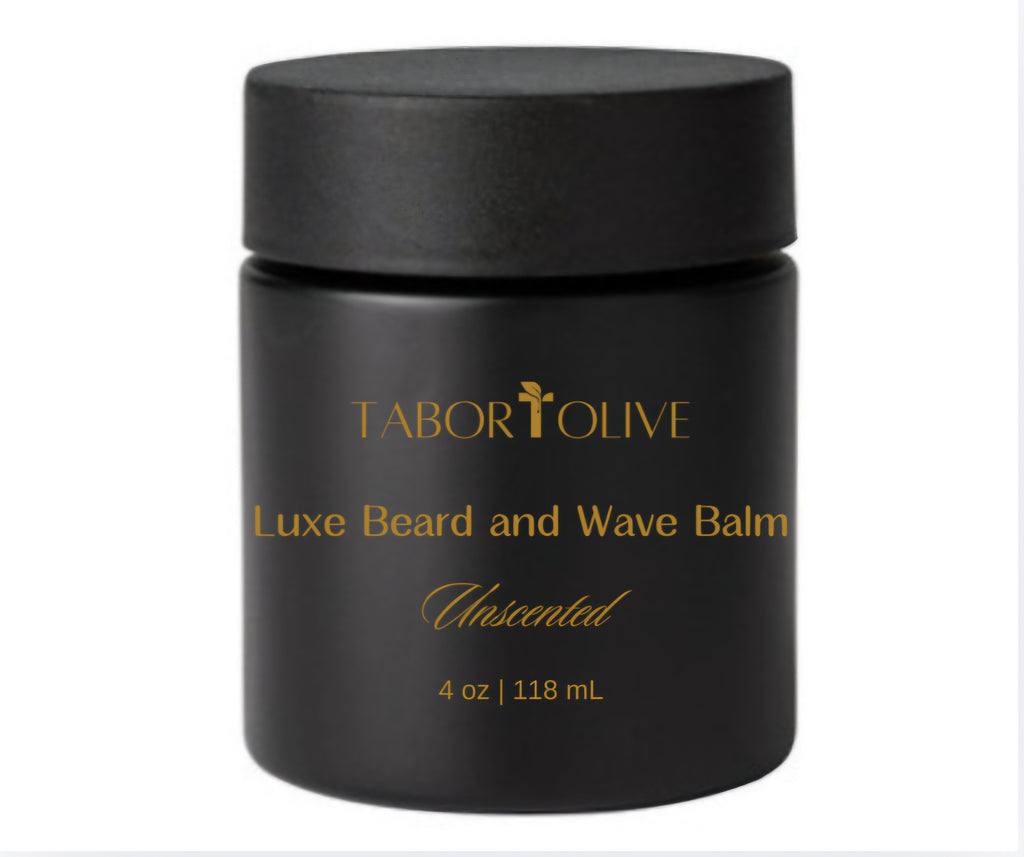 Black glass jar and lid with gold text that says, "Luxe Beard and Wave Balm. All Natural & Non-GMO. Unscented."