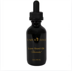 Black vial bottle with gold text that says "luxe beard oil. Unscented. All natural non-GMO and Vegan."